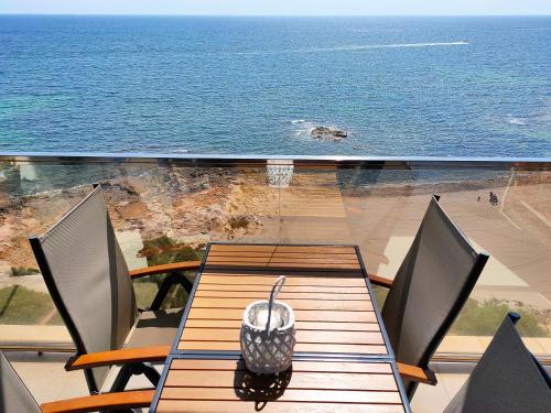 una mesa y sillas con vistas al océano en Veneziola Paraíso Apartament, en La Manga del Mar Menor