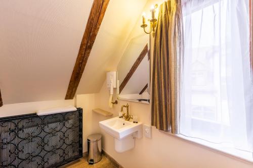 a bathroom with a sink and a window at Hotel Am Ring in Sibiu