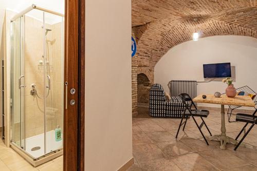 a bathroom with a shower and a table and chairs at B&B IL Cammino in Lanciano
