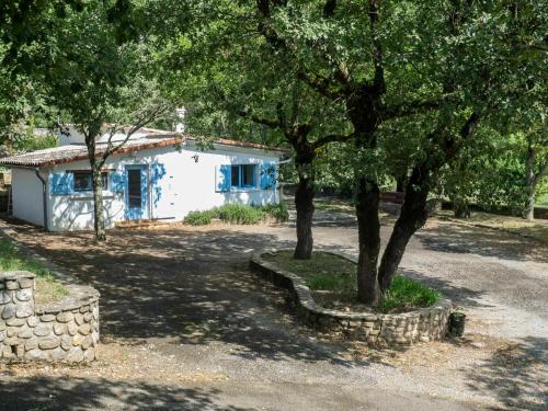 uma casa com uma árvore e uma parede de pedra em Adorable holiday home with pool em Uzer