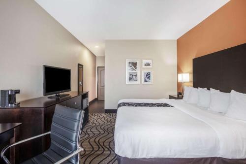 a hotel room with a bed and a flat screen tv at La Quinta by Wyndham Beeville in Beeville