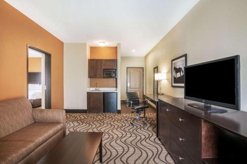 a living room with a couch and a flat screen tv at La Quinta by Wyndham Beeville in Beeville