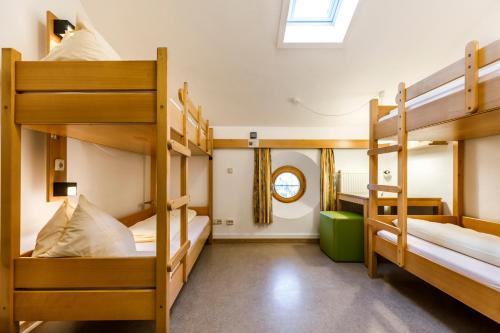 a room with three bunk beds and a window at Jugendherberge Eichstätt in Eichstätt