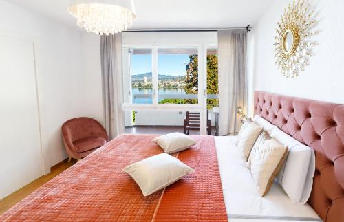 a bedroom with a large bed with a large window at Sunset View Apartment - 2 Bedrooms in Veytaux