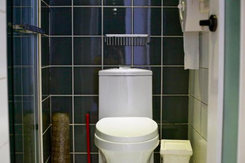 a bathroom with a white toilet and black tiles at Peking Youth Hostel in Beijing
