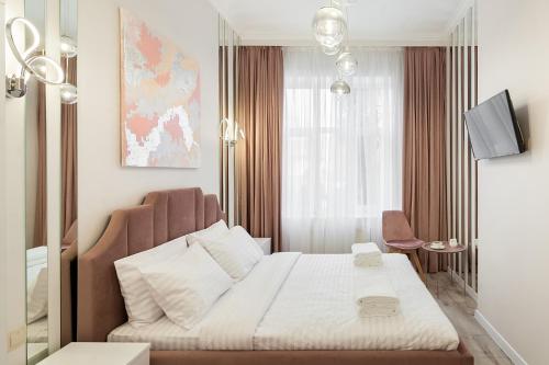 een slaapkamer met een wit bed en een stoel bij Avangard DeLuxe Art Apart in Lviv