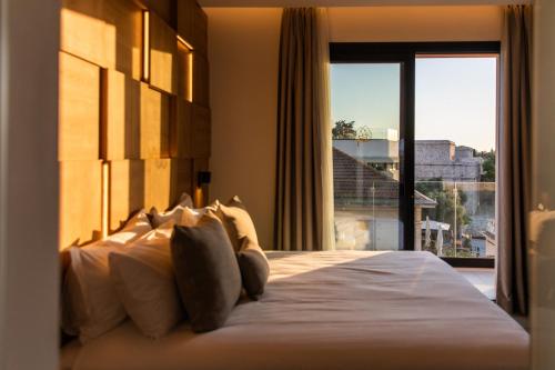 a bedroom with a large bed with a large window at Old Port Hotel in Limassol