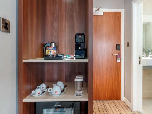 a room with a shelf with tea pots and a coffee maker at Garner Hotel Preston Samlesbury by IHG in Preston