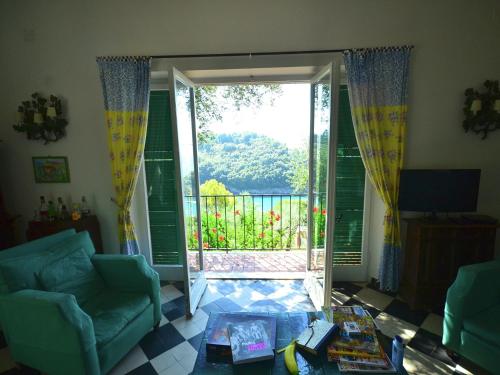 a living room with a door open to a balcony at Belvilla by OYO Villa Shakti in Lerici