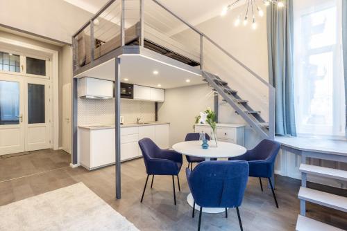 un pequeño comedor con mesa y sillas azules en W33 - Prime Location - Comfortable Quality Apartments by BQA, en Budapest