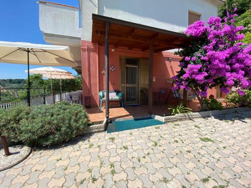 Silvi PaeseにあるB&B Santa Luciaの紫の花の木とパティオ付きの家