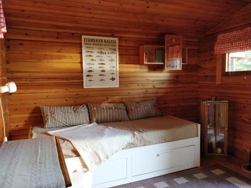 1 dormitorio con 1 cama en una cabaña de madera en Villa Kommodor, en Lumparland
