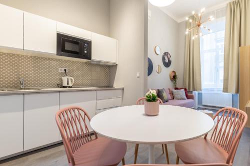 una cucina e una sala da pranzo con tavolo e sedie bianchi di W33- Quality Apartments, Best Location. By BQA a Budapest