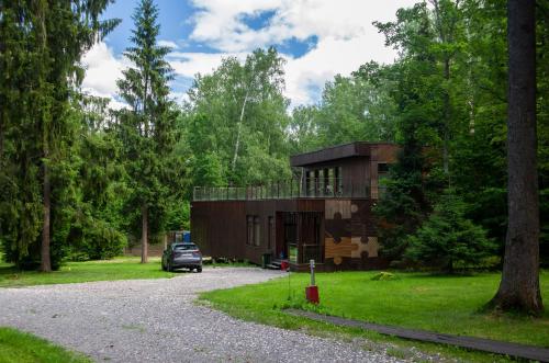 a car parked in front of a house in the woods at Berta Village in Buzharovo