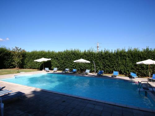ein großer Pool mit Stühlen und Sonnenschirmen in der Unterkunft Belvilla by OYO I Molinari in Gualdo Cattaneo