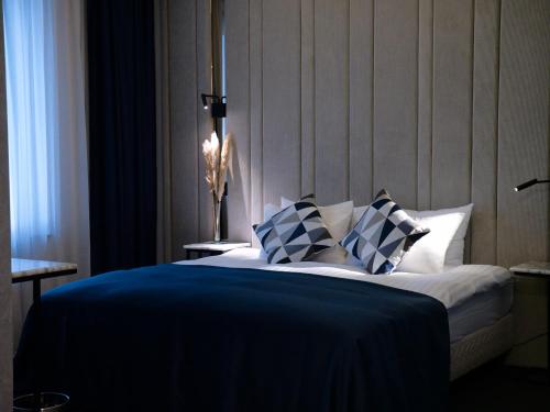 um quarto com uma cama com almofadas azuis e brancas em Union Plaza Hotel em Bucareste