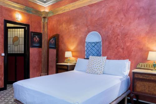 1 dormitorio con cama blanca y pared roja en Flateli Peixateries Velles, en Girona