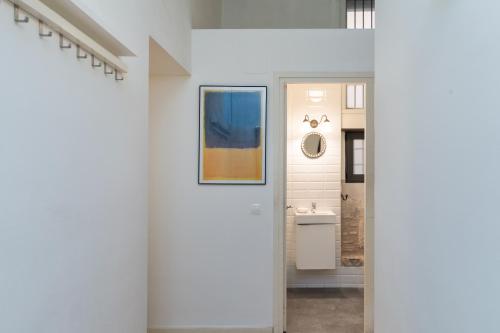 pasillo blanco con lavabo y espejo en Flateli Peixateries Velles, en Girona