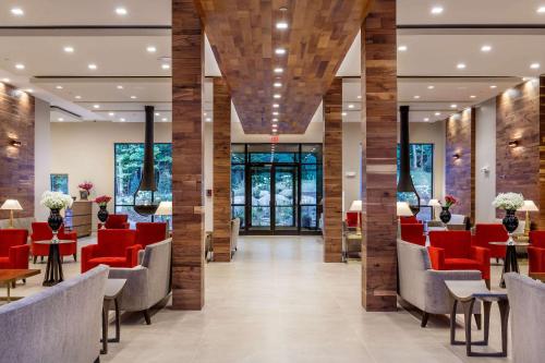 un hall d'un hôpital avec des chaises et des tables rouges dans l'établissement The Chandler at White Mountains, Ascend Hotel Collection, à Bethlehem