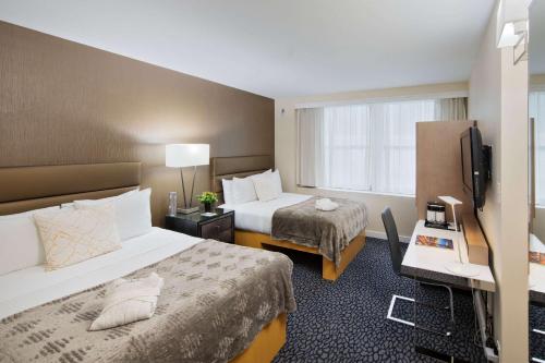 a hotel room with two beds and a television at The Historic Blue Angel Hotel Lexington Ave, an Ascend Collection in New York