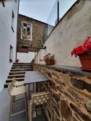 a patio with a table and two chairs and stairs at Albergue Casa Cuartel in Fonsagrada