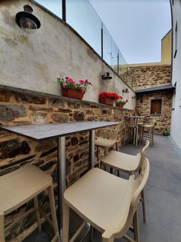 a restaurant with tables and chairs and a brick wall at Albergue Casa Cuartel in Fonsagrada
