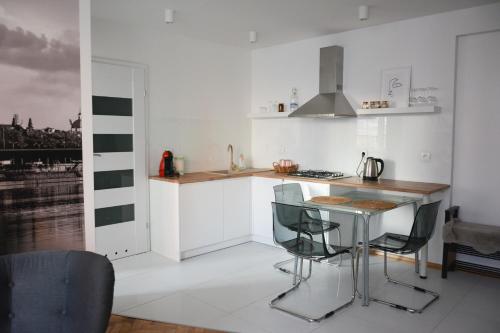 a white kitchen with a table and chairs in it at Apartament Centrum Warszawy in Warsaw