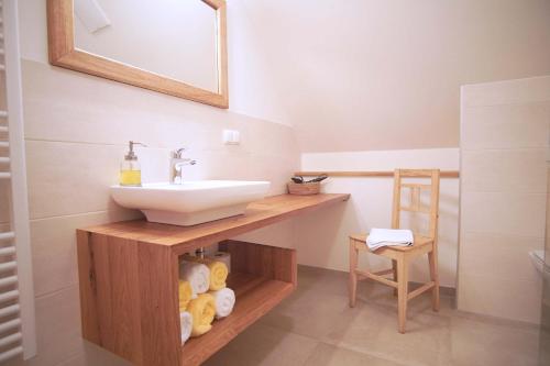 a bathroom with a sink and a shelf with towels at Bauernhof Gschmeidler in Sankt Johann im Saggautal