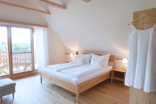 a bedroom with a bed and a large window at Bauernhof Gschmeidler in Sankt Johann im Saggautal
