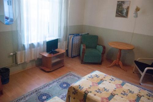 a living room with a bed and a chair and a table at Villa Freven in Pärnu