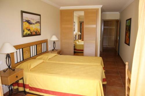 a bedroom with a large yellow bed in a room at Apartamento T1 - Praia Senhora da Rocha in Porches