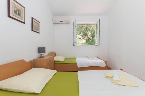 two beds in a small room with a window at Villa Ozzi with 9 bedrooms & private Pool in Makarska