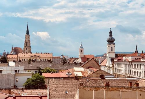 Blick auf eine Stadt mit Gebäuden und Kirchen in der Unterkunft Hotel Victoria in Cluj-Napoca