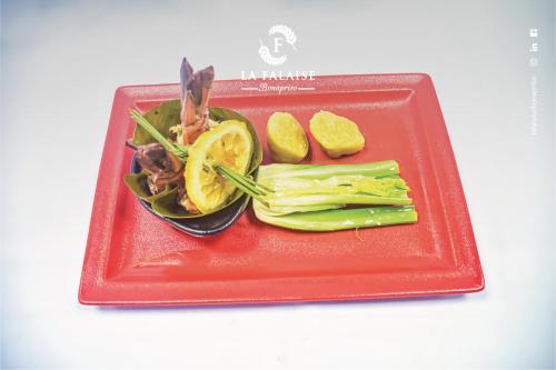 a plate of food with vegetables on a red plate at Hotel La Falaise Bonapriso in Douala