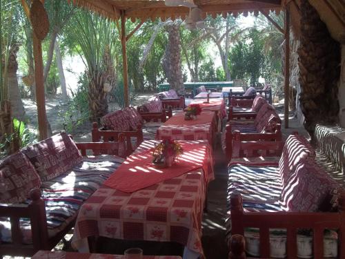 un restaurant avec des tables, des chaises et des nappes rouges et blanches dans l'établissement Nour El Gourna, à Louxor