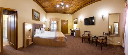 a hotel room with a bed and a table and chairs at Hotel Am Ring in Sibiu