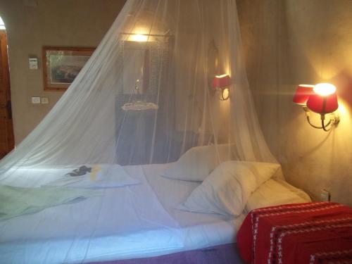 a bedroom with a white bed with a mosquito net at Nour El Gourna in Luxor