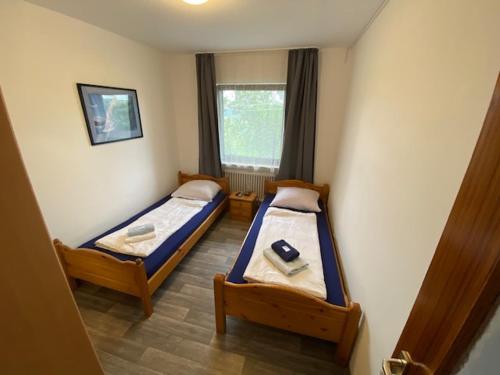 twee bedden in een kleine kamer met een raam bij Monteurswohnung Zimmerfrei Marktheidenfeld in Marktheidenfeld