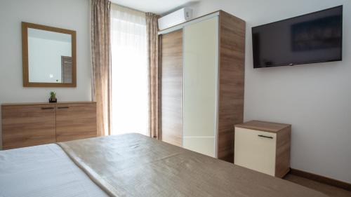 a bedroom with a bed and a flat screen tv at Rooms & Apartments Toni in Split