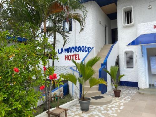 a hotel with palm trees in front of a building at Hotel La Madrague in Grand-Bassam