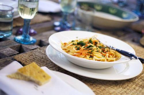 a bowl of pasta on a plate on a table at The Majlis Resort in Lamu