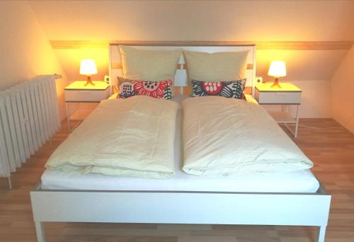 a bedroom with a large white bed with two lamps at 4-Zimmer Haus in Leipzig in Leipzig