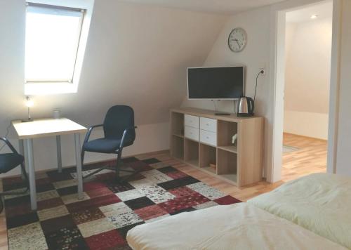 a bedroom with a desk and a television and a chair at 4-Zimmer Haus in Leipzig in Leipzig