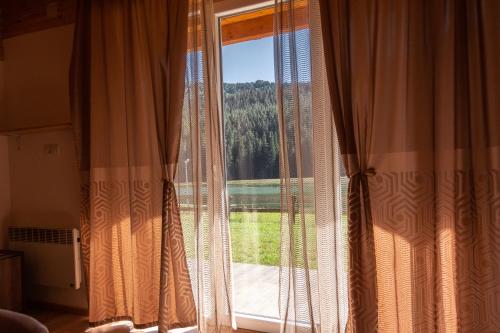 a window with curtains in a room with a view at Etno selo Zminica in Žabljak