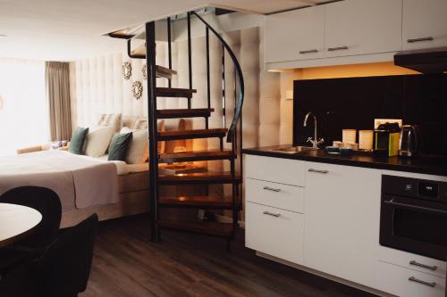 a kitchen with a bed and a spiral staircase in a room at City Attic Haarlem in Haarlem