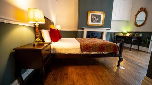 a bedroom with a bed and a lamp on a table at Georgian Townhouse in Bristol