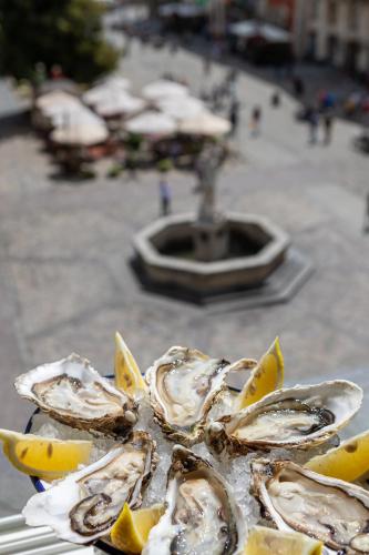 a group of oysters with lemon slices on a table at Oysters & Bubbles Gastro Hotel. Rynok square in Lviv