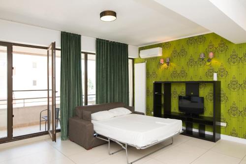 a bedroom with a bed and a tv and green walls at Green Lake Apartment 5 in Mamaia