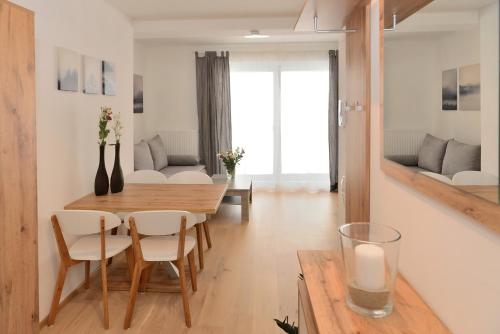 a dining room and living room with a table and chairs at Apartment Serles in Mühlbachl