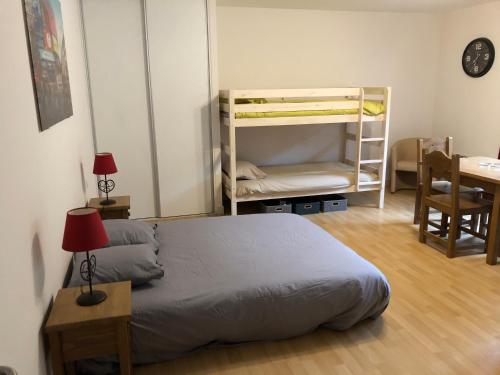 a bedroom with a bed and a desk and a bunk bed at Appartement 4 personnes aux pieds des pistes, Ariège in Ustou